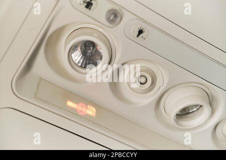 Buenos Aires, Argentina, November 18, 2022: Control panel of lights and air-conditioning system on the ceiling above the passenger seat in the cabin o Stock Photo