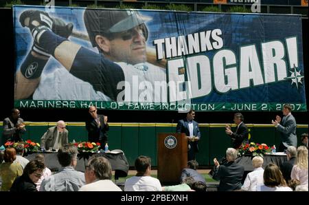 New York Yankees pitcher Mariano Rivera, left, waves to the crowd after  accepting a check for the Mariano Rivera Foundation from Seattle Mariners'  former designated hitter Edgar Martinez, right, prior to a