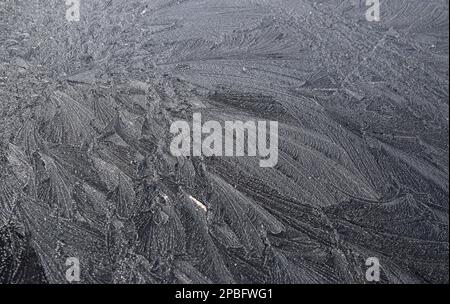 Frost with feather like patterns on the hood of my car in early March Stock Photo