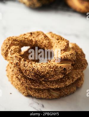 Close up ofTurkish simit bread pretzels stack. Homemade Sesame bagel on dark background. Low key, dark photo Stock Photo