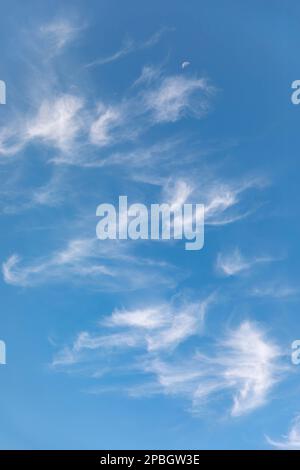 Clouds and moon against a beautiful blue sky Stock Photo