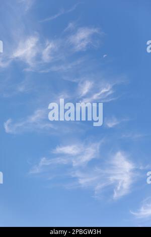 Clouds and moon against a beautiful blue sky Stock Photo