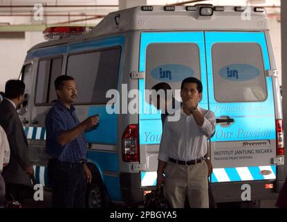 Mokhzani Mahathir, son of former Prime Minister Mahathir Mohamad, 2nd left, stands next to the ambulance carrying his father on the arrival at the National Heart Institute in Kuala Lumpur, Malaysia, Tuesday, May 15, 2007. Mahathir Mohamad was shifted to the heart institute in Kuala Lumpur on Tuesday after receiving overnight emergency treatment while on a holiday, officials said. (AP Photo/Andy Wong)