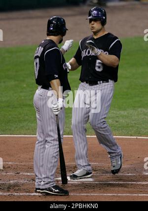 Colorado Rockies' Matt Holliday, right, gets a high-five from teammate  Jorge Piedra after scoring a run on a hit by Brad Hawpe off Los Angeles  Angels pitcher John Lackey in the sixth