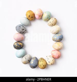 Colorful pastel Easter eggs in egg shape on white background. Easter greeting card, copy space. Top view. Stock Photo