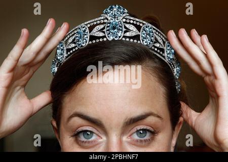 A Sotheby's employee presents a tiara from Lady Hesketh's collection dates  from circa 1910,which is composed of a serie of sky-blue oval aquamarines,  surrounded by similar stones set among diamond-encrusted, during a