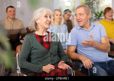 Group of older students sitting and listening at lesson Stock Photo