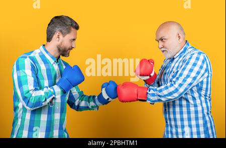 two generation men boxing isolated on yellow. generation men boxing in studio. Stock Photo