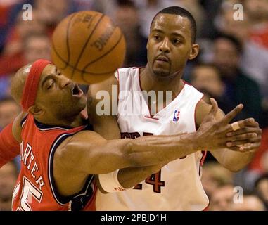 Toronto Raptors Morris Peterson right passes the ball under