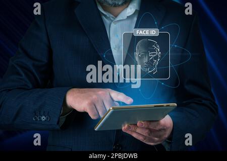 Man using tablet with face id scan and modern technology. Login using Face id and AI Stock Photo