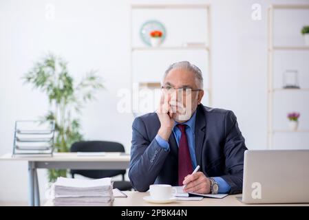 Old businessman employee working at workplace Stock Photo