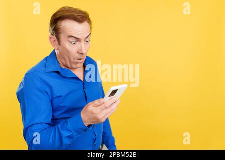 Surprised mature man looking at the mobile phone Stock Photo