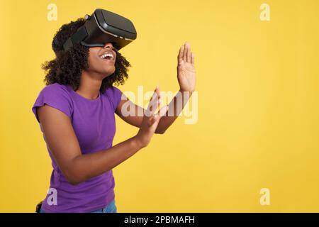 Curious afro woman gesturing while wearing a virtual reality goggles Stock Photo