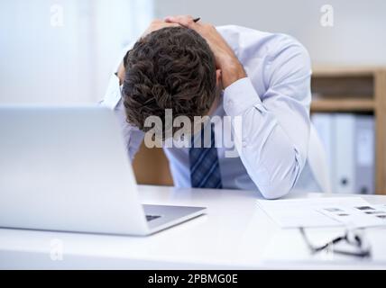 Totally and utterly exhausted. an tired-looking businessman in an office. Stock Photo