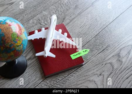 Selective focus image of toy plane, world globe and passport with text TRAVEL TIPS. Travel and transportation concept Stock Photo