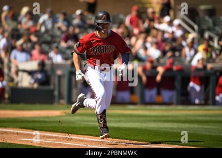 Arizona Diamondbacks center fielder Corbin Carroll (7) singles on a fielding error by Colorado Rockies shortstop Ezequiel Tovar (14) in the second inning of an MLB spring training Baseball game at Salt River Fields, Sunday, Mar. 12, 2023, in Phoenix, AZ. The Diamondbacks defeated the Rockies 10-9. (Thomas Fernandez /Image of Sport) Stock Photo