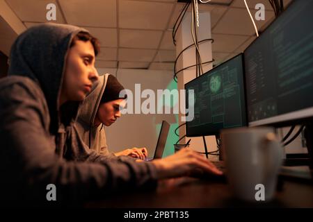 Hackers breaking into government database, stealing information, internet thieves cracking password, using spyware. Cybercrime, man and woman hacking computer system, coding malicious software Stock Photo