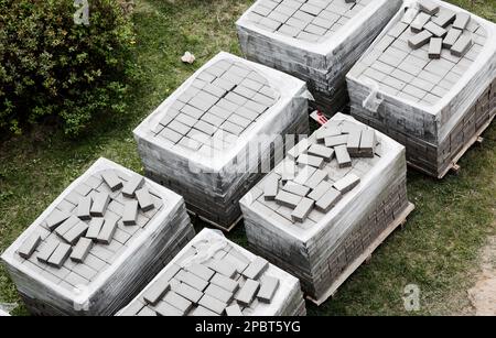 Pallets with stacked gray paving slabs. Stack of paving slabs in warehouse, road repair or finished tile sale, top view Stock Photo