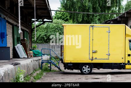 yellow micro van.  delivery truck parked near the warehouse Stock Photo