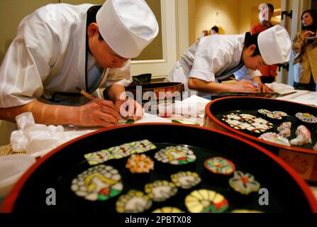 Nobu Yamazaki left and Masaya Kitayama carve designs into bamboo