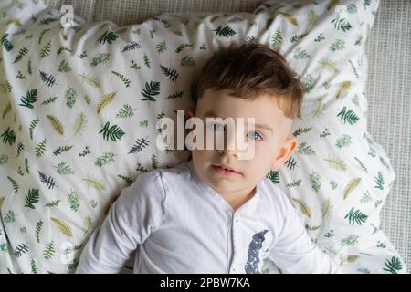 Happy little child boy in pajamas, in bed in the bedroom with to Stock Photo