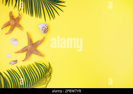 Summer minimal background with orange starfishes, shells and palm tree on yellow background. Aesthetic photography. Travel. Copy space Stock Photo