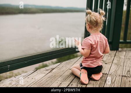 Child looking at river from overlook Stock Photo