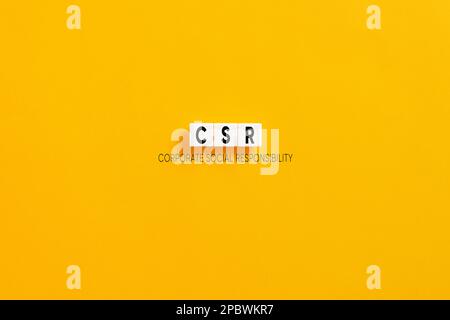 White letter blocks on yellow background with the acronym CSR corporate social responsibility. Stock Photo