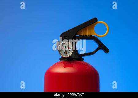 Fire extinguisher pressure gauge. Close up studio shot, isolated on blue background, no people. Stock Photo