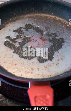 Dirty oily burnt non-stick frying pan or skillet. Close up studio macro shot, isolated. Stock Photo