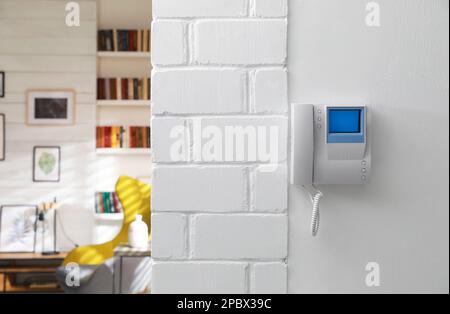 Modern intercom with camera installed on white wall indoors Stock Photo