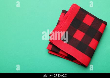 Folded red checkered bandana on turquoise background, top view. Space for text Stock Photo