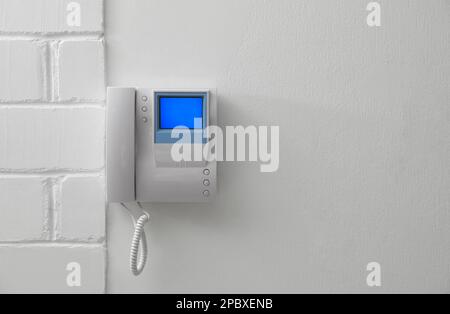 Modern intercom with camera installed on white wall Stock Photo