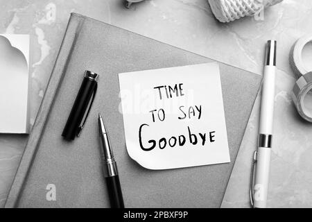 Note with text Tome to say Goodbye and stationery on table, flat lay. Black and white tone Stock Photo