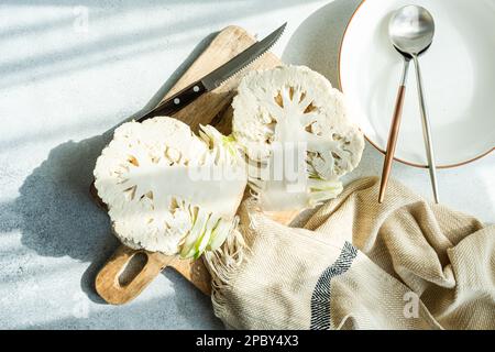 Raw cauliflower vegetable ready for cooking on concrete table Stock Photo