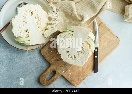 Raw cauliflower vegetable ready for cooking on concrete table Stock Photo