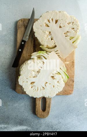 Raw cauliflower vegetable ready for cooking on concrete table Stock Photo