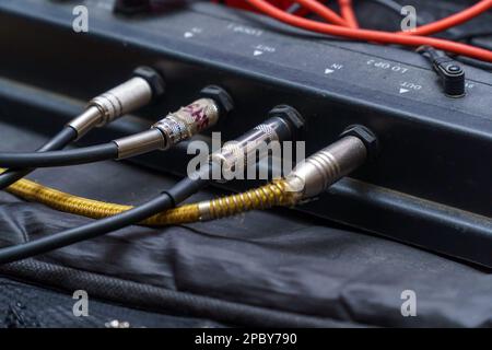 Audio jacks are plugged into a guitar synthesizer or processor Stock Photo