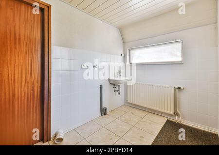 Interior design of light bathroom with sink and chrome faucet near radiator and wooden door decorated with ceramic tile and gray rug Stock Photo