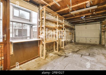 Interior of old shabby garage with brick walls and shelves near cupboards illuminated by lamps Stock Photo