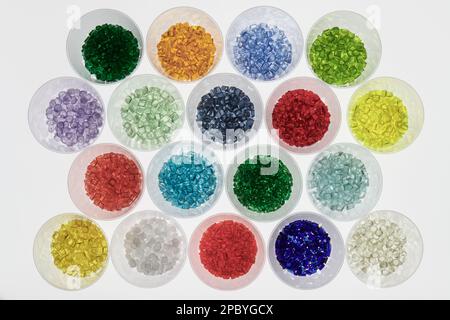 several transparent colored plastic resin granulates in test glasses in laboratory. Mass for injection molding and extrusion process Stock Photo