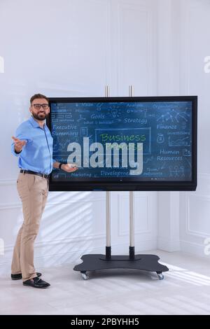 Business trainer using interactive board in meeting room Stock Photo