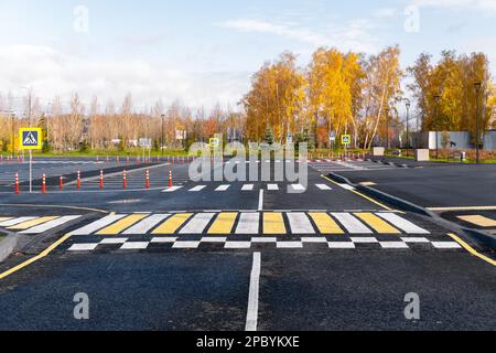 The white and yellow lines of the pedestrian crossing at the intersection of roads in the city. Road safety. Zebra road markings, crossing point of th Stock Photo