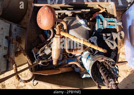 A collection of old vintage rusted hand tools and large drill bits in a wooden box  at a market on the Central Coast of New South Wales, Australia Stock Photo