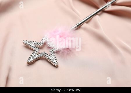 Beautiful silver magic wand with feather on pink fabric Stock Photo