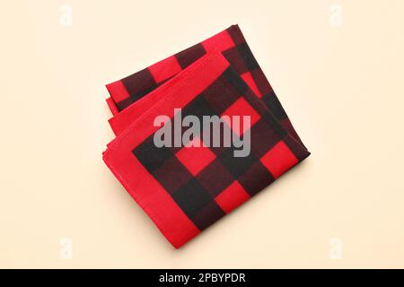 Folded red checkered bandana on beige background, top view Stock Photo