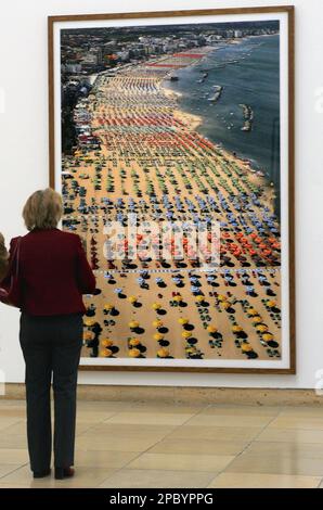 A woman stands in front of the picture 