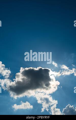 Dramatic puffy white clouds in the blue sky, sun cover behind the clouds, summed day, no people.. Stock Photo