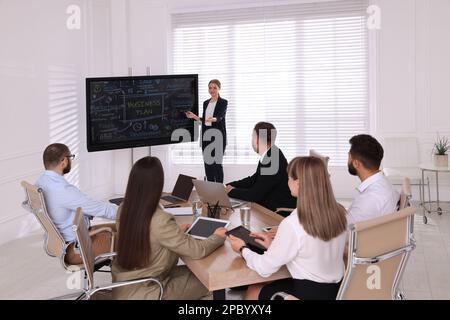 Business trainer using interactive board in meeting room during presentation Stock Photo