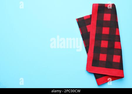 Folded red checkered bandana on light blue background, top view. Space for text Stock Photo